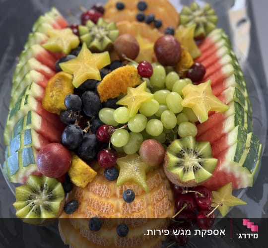 מגש פירות מעוצב עם כוכבי קרמבולה וענבים
